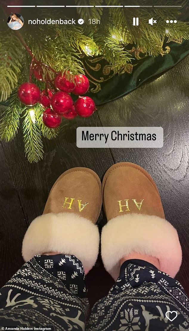 Cosy: Amanda also showed her personalised fluffy slippers, which had her initials - Amanda Holden Enjoys The Festivities By Flaming A Christmas Pudding In A Busty Satin Teal Dress'AH' emblazoned in gold as she posed her feet next to her beautifully decorated Christmas tree