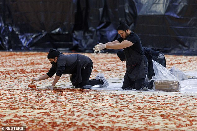 It was put together inside the Los Angeles Convention Center, with a team of workers painstakingly placing layers of dough, before covering them up with sauce and cheese - Pizza Hut Breaks The Guinness World Record For BIGGEST Ever Pizza